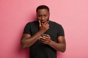 Man holding an iPhone experiencing slower performance after a major iOS update